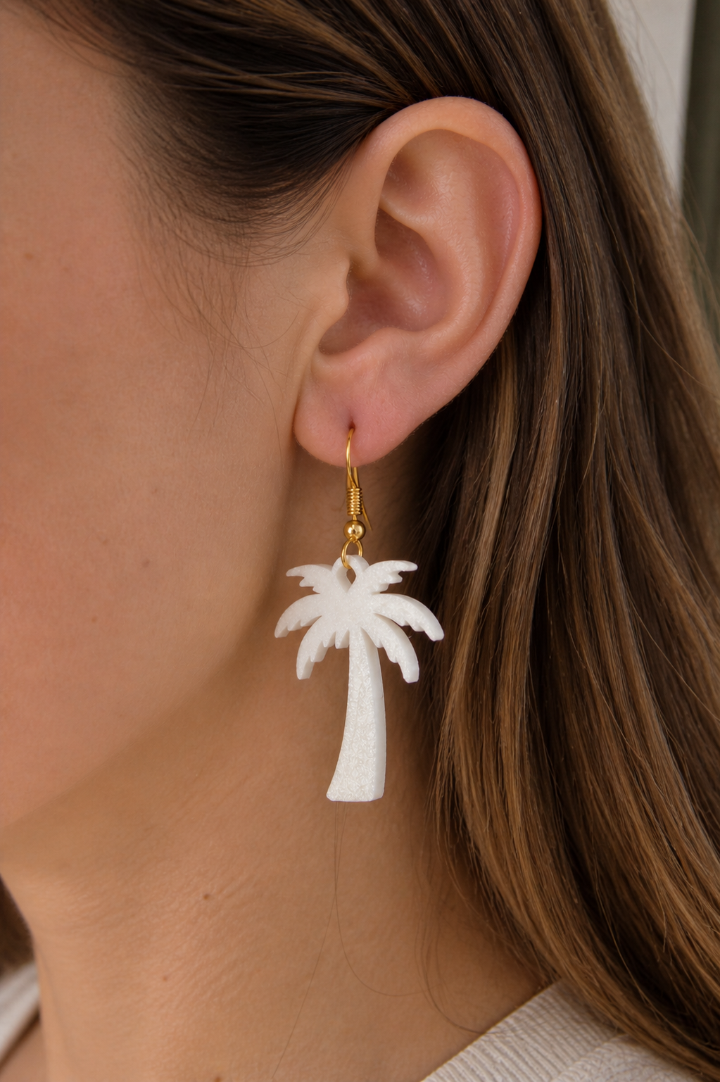 White palm tree earring with gold hooks. Model View