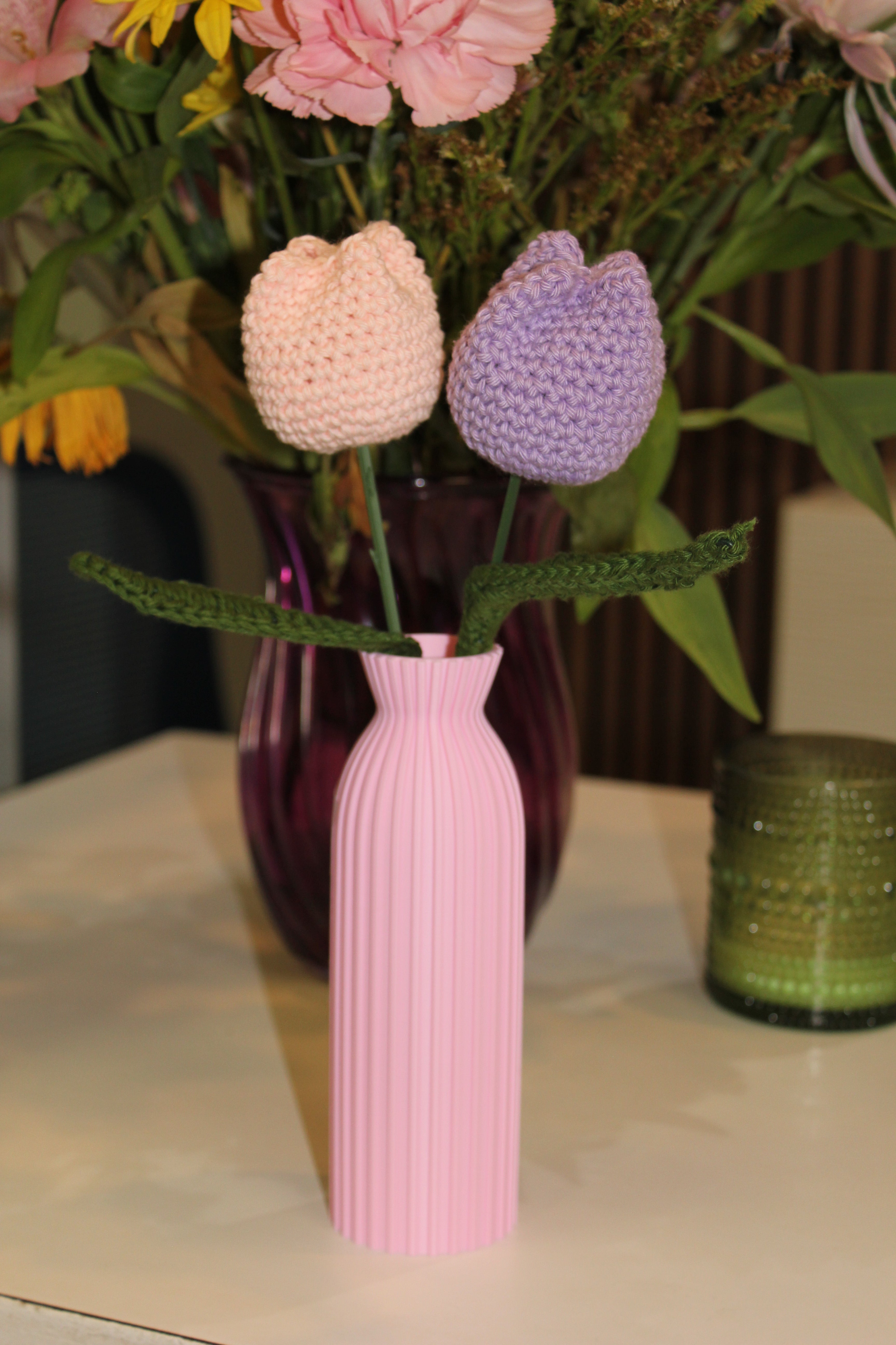 Decorative pink vase with 2 crochet tulips in it pink and purple. Front view