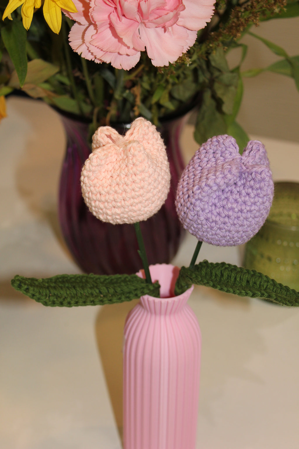 Decorative pink vase with 2 crochet tulips in it pink and purple. Top view