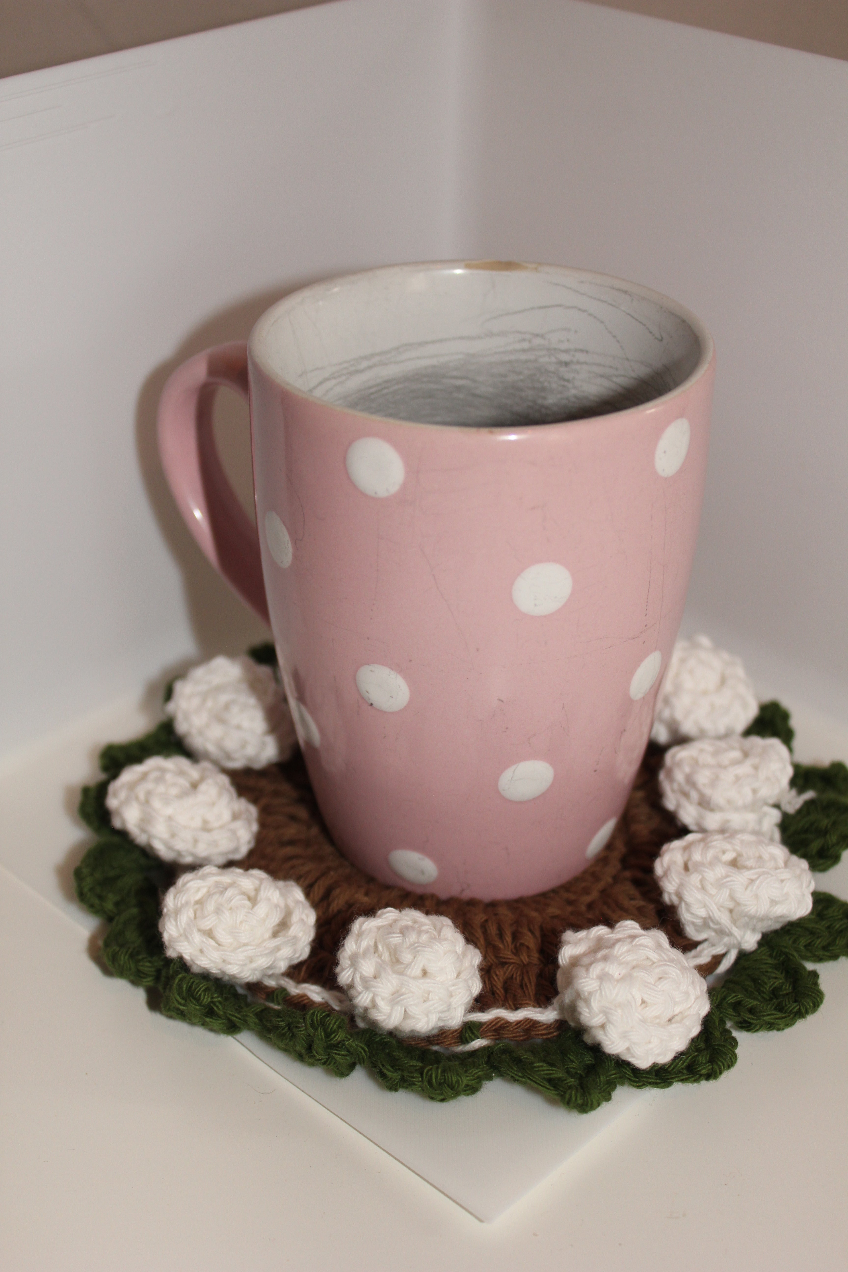 white roses green leaves coaster with tea cup on top