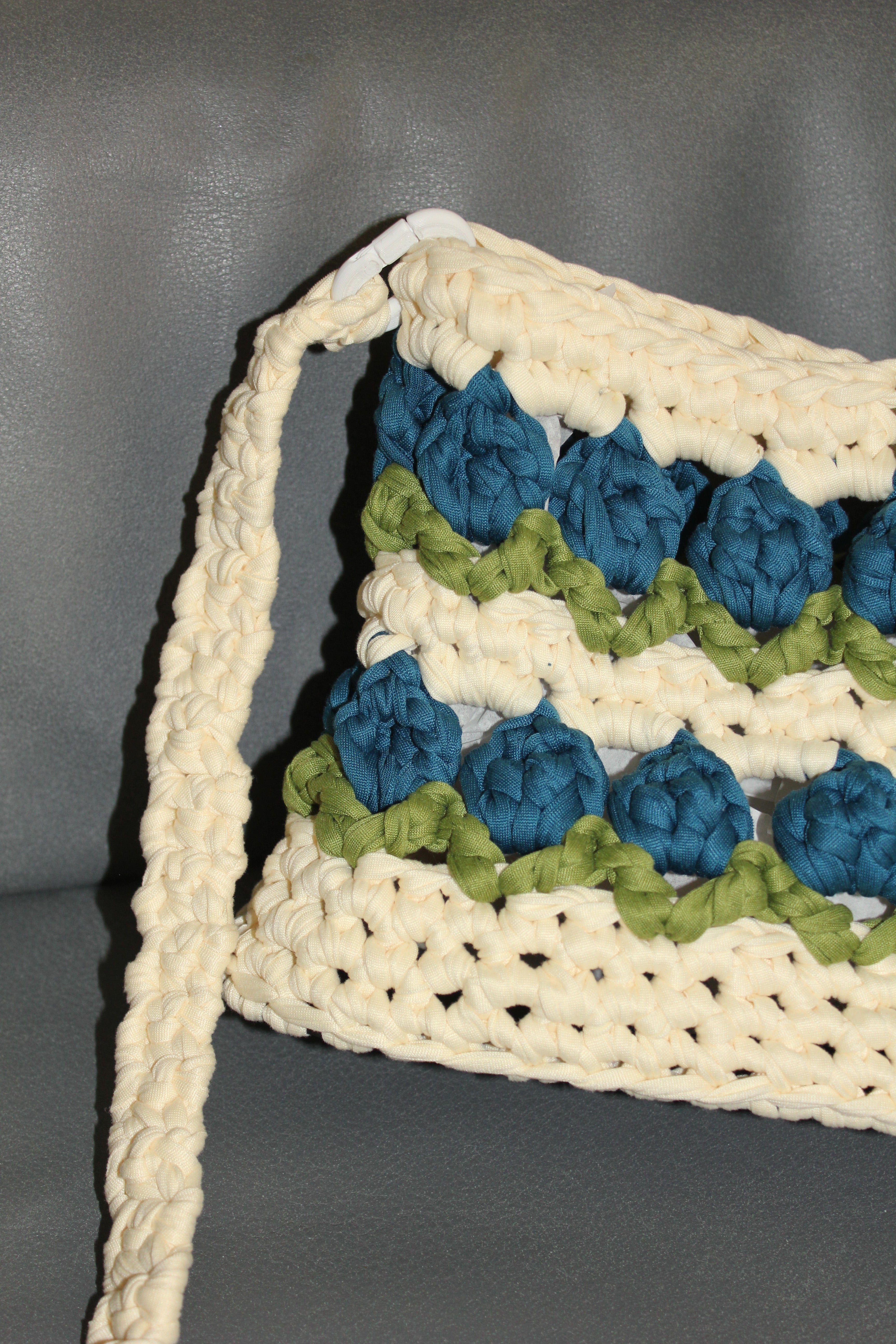Crocheted tulip bag with blue and green flowers. Close-up view