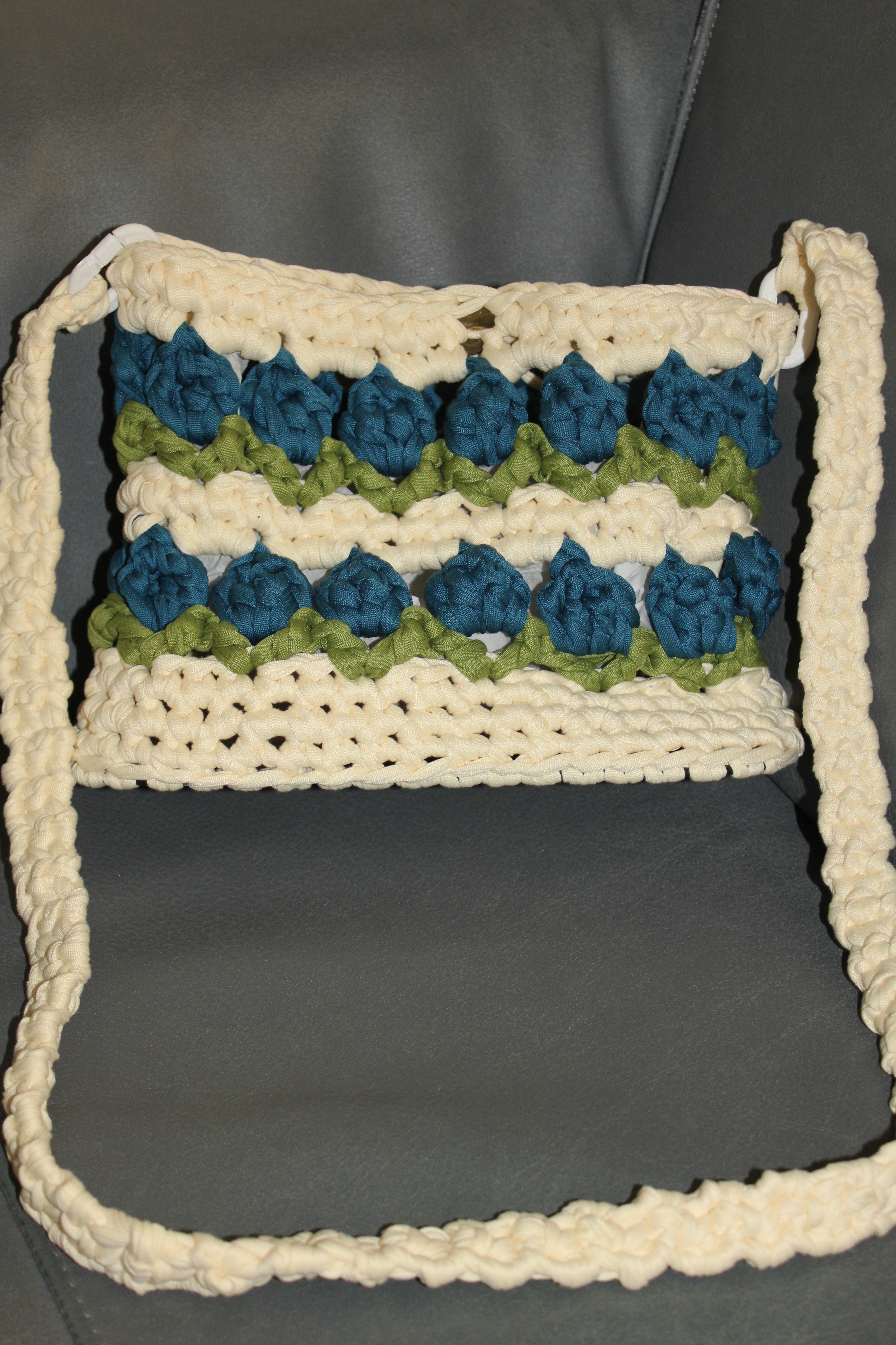 Crocheted tulip bag with blue and green flowers. Front view