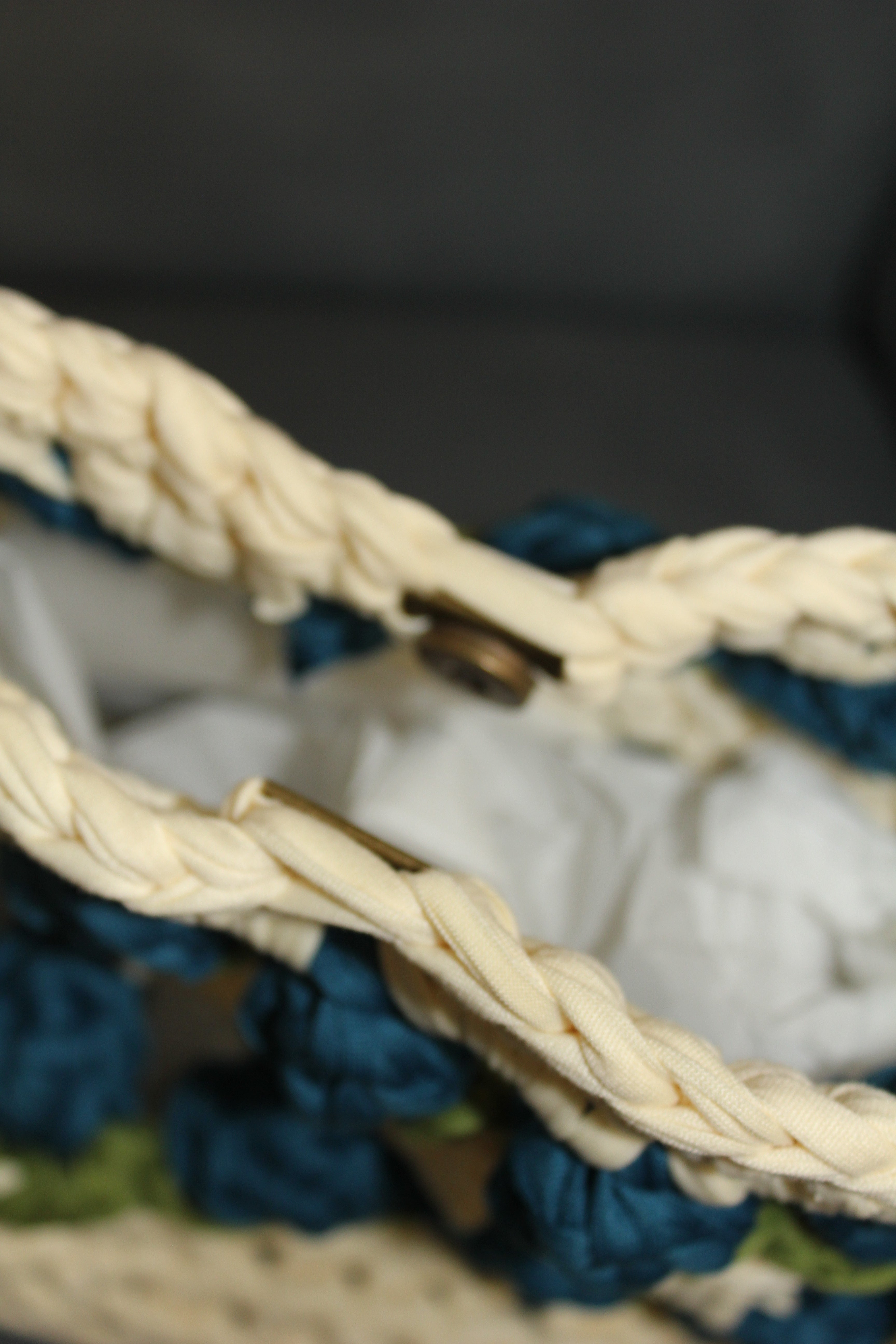 Crocheted tulip bag with blue and green flowers. Clasp closing view