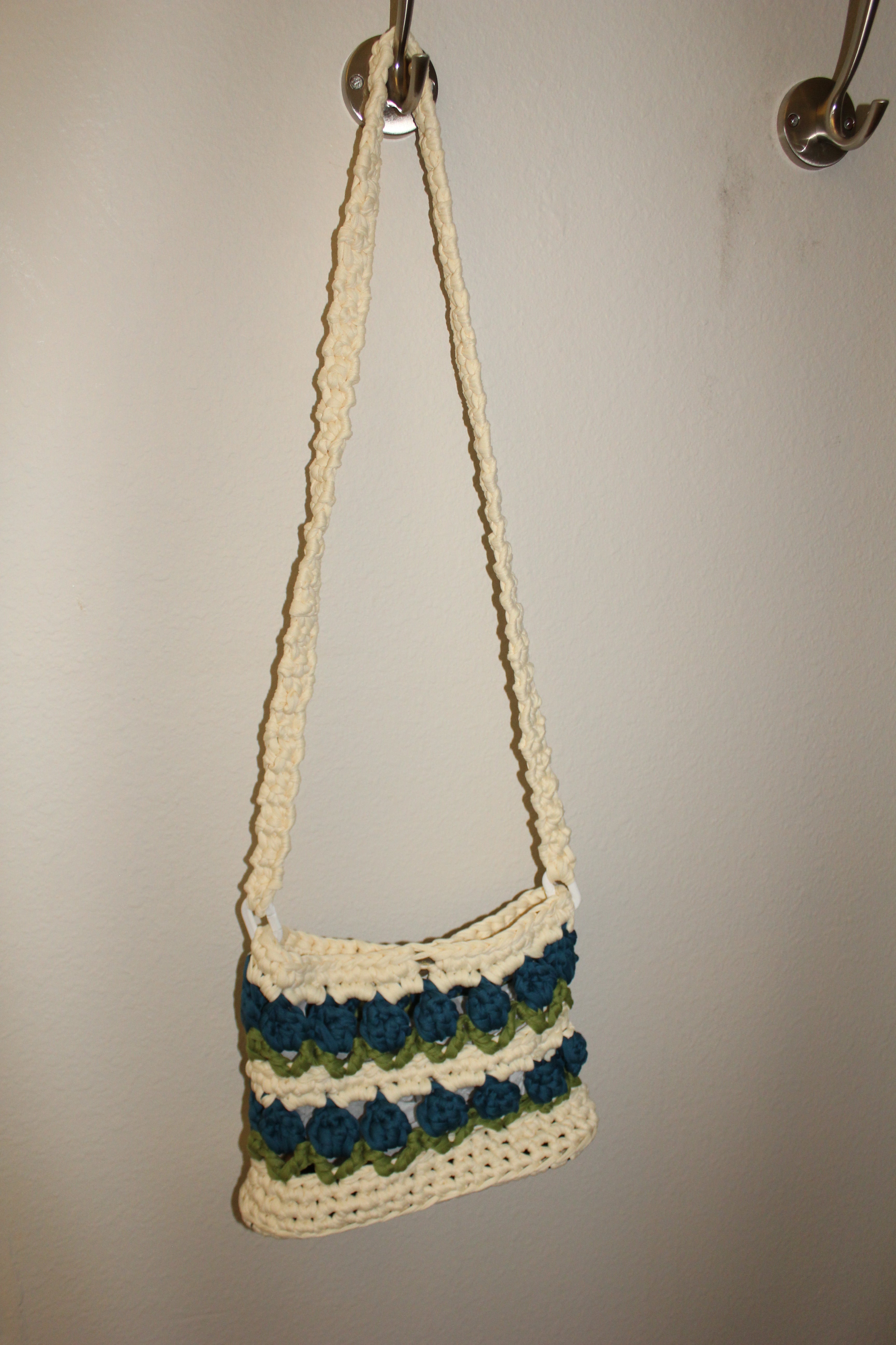 Crocheted tulip bag with blue and green flowers. Distance view